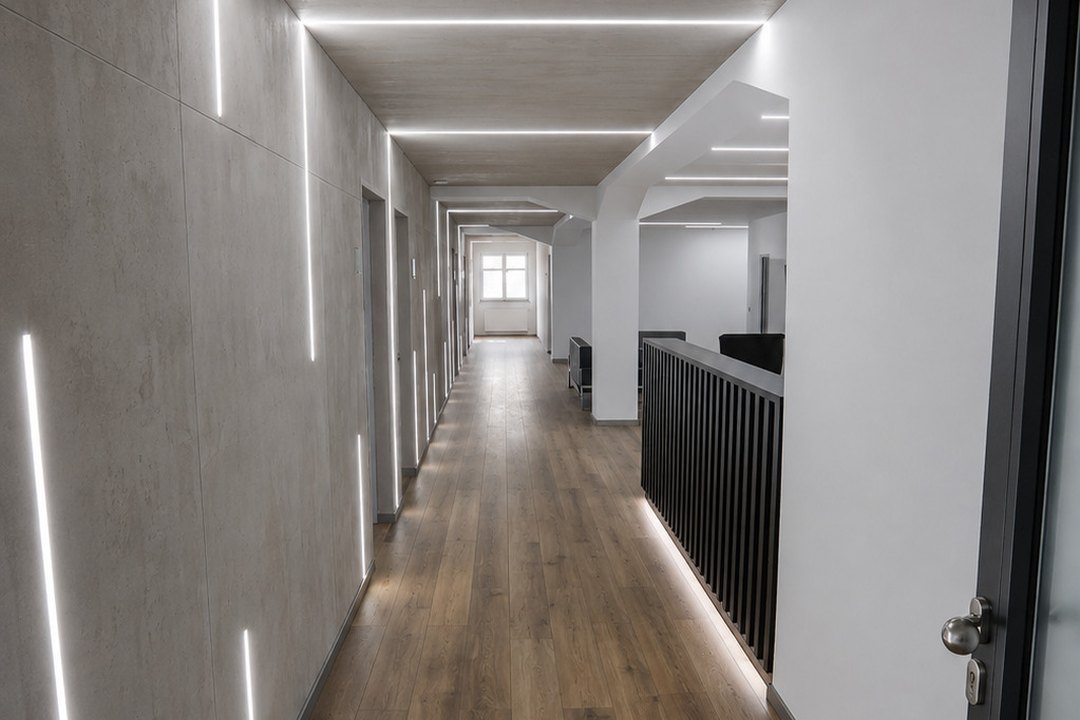 Eingangsbereich im Office Center: Flur mit LED-Lichtlinien, Wand in Betonoptik und Empfangstresen