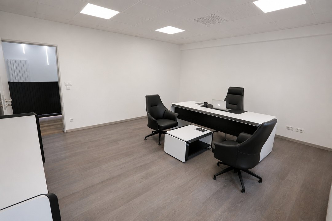 Büro mit Schreibtisch und Besuchersesseln, offener Durchgang zum Flur
